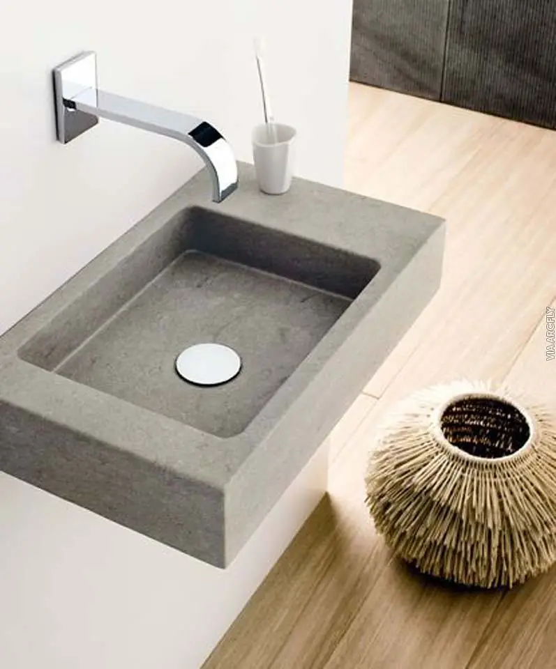 A modern stone wash basin with a wall-mounted tap