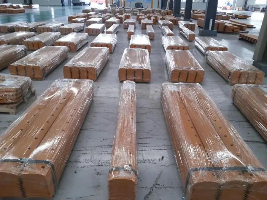 Grader blades packed on pallets in a warehouse