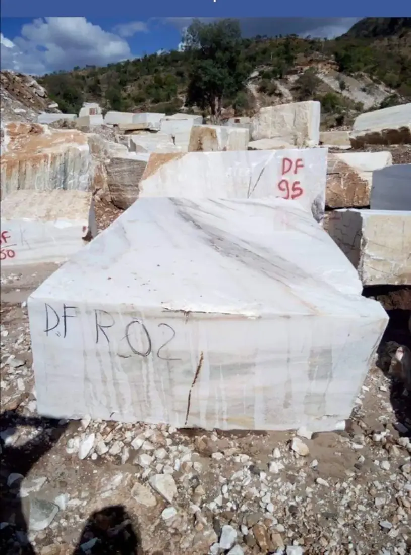 A white marble block marked for supply at the quarry