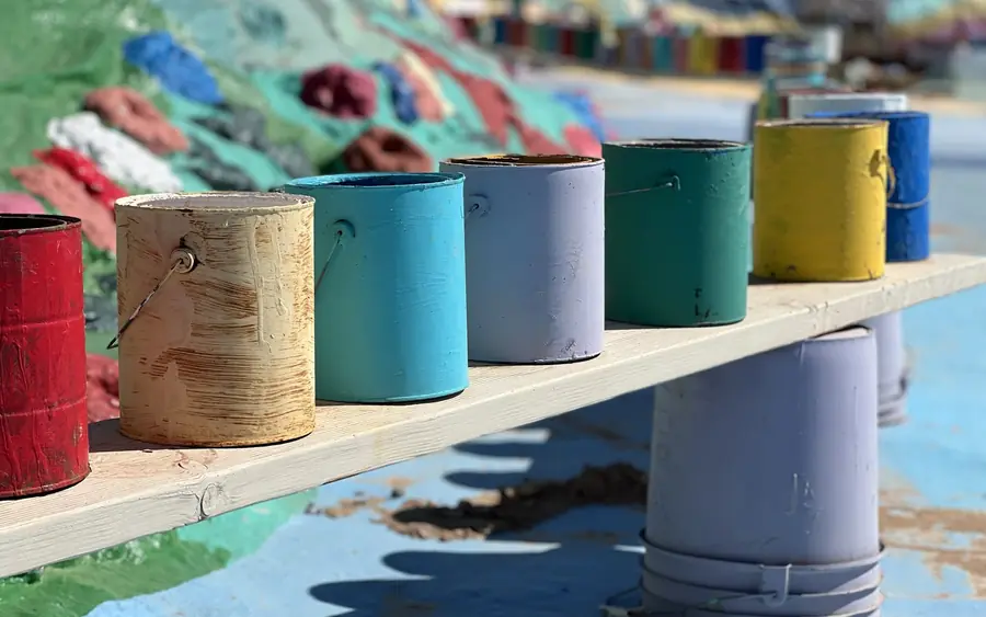 A row of brightly coloured paint cans