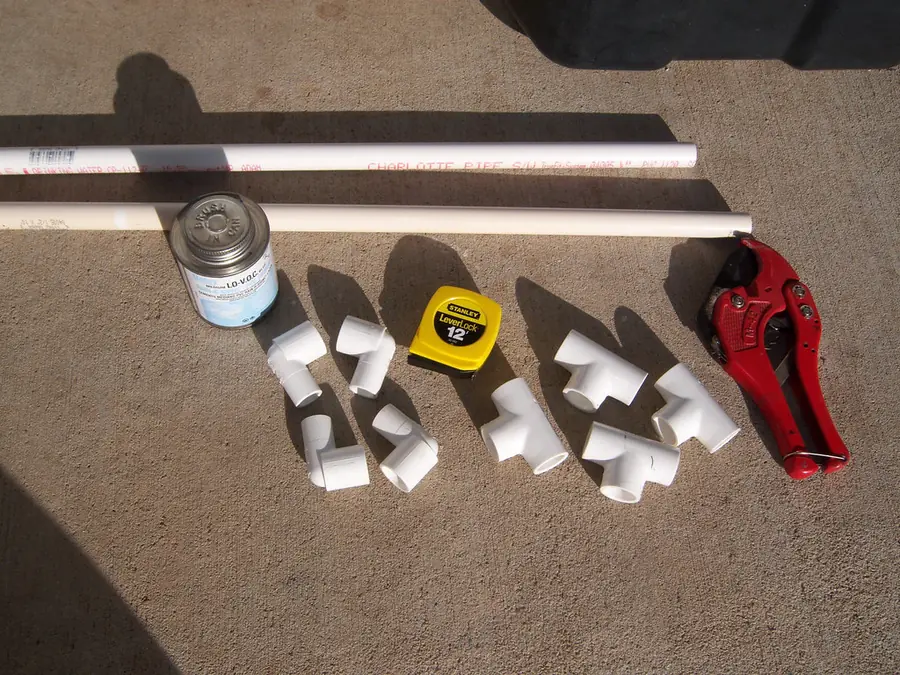 PVC pipes, elbow fittings, solvent cement, a tape measure and a pipe cutter
